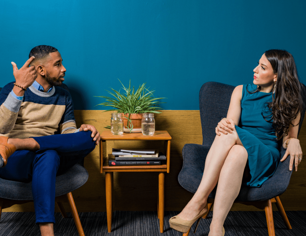 Man And Women Sitting In Chairs Talking